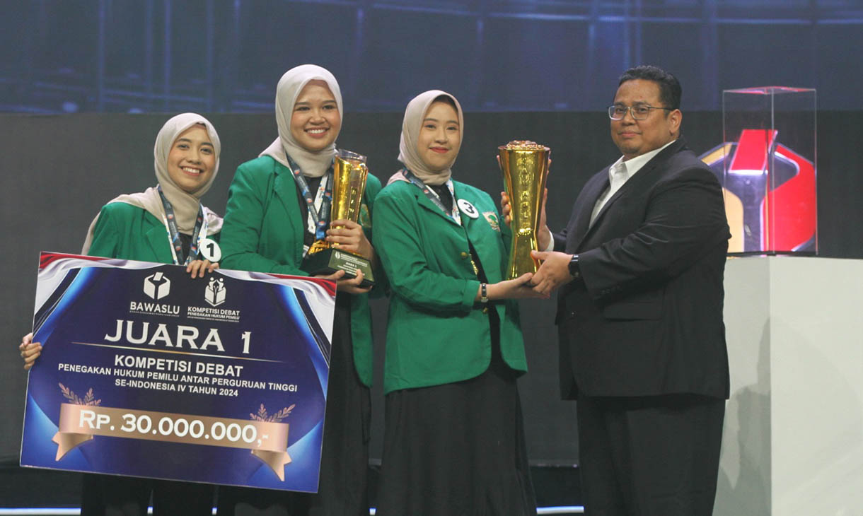 Ketua Bawaslu RI Rahmat Bagja memberikan piagam penghargaan Juara I kepada peserta dari Universitas Andalas di akhir Kompetisi Debat Penegakan Hukum Pemilu Perguruan Tinggi se-Indonesia yang berlangsung di Jakarta, Rabu (23/10/2024). Dok. (BeritaNasional.com/Oke Atmaja)